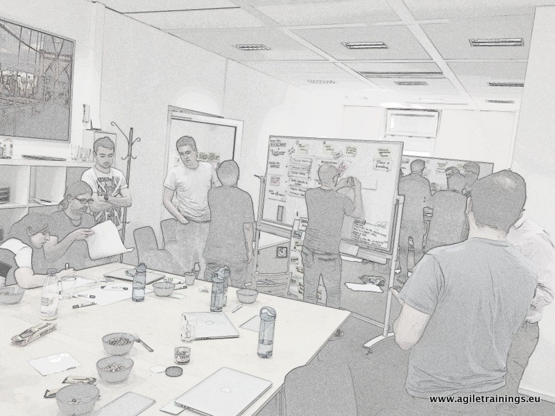 Cluster of people at a whiteboard sketching during the refinement meeting