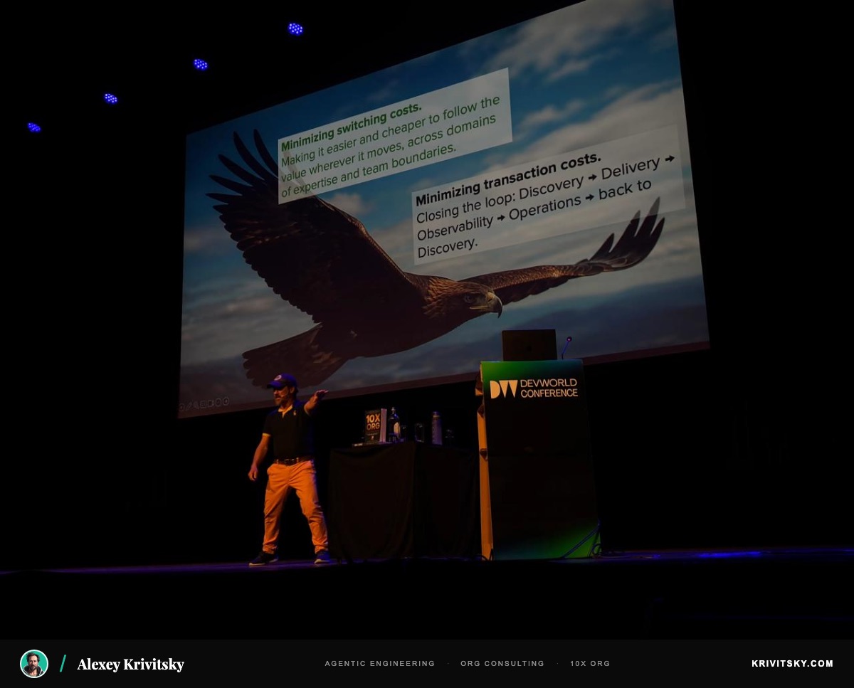 Alexey Krivitsky on stage at DevWorld Conference — two wings: minimizing switching costs and transaction costs